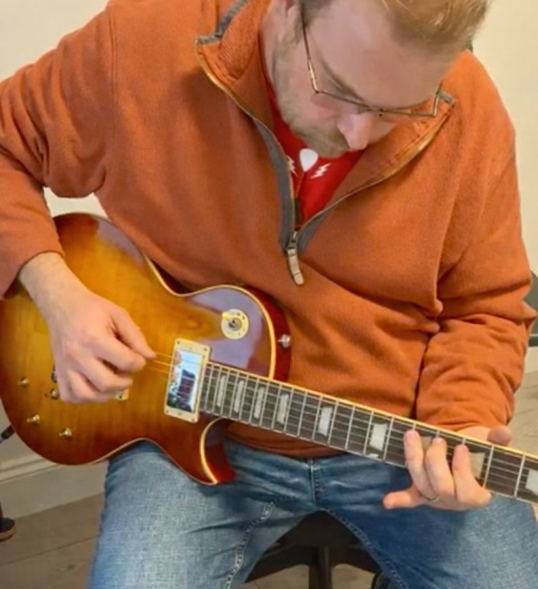Guitar pickup final testing by hand during play-testing at the bench
