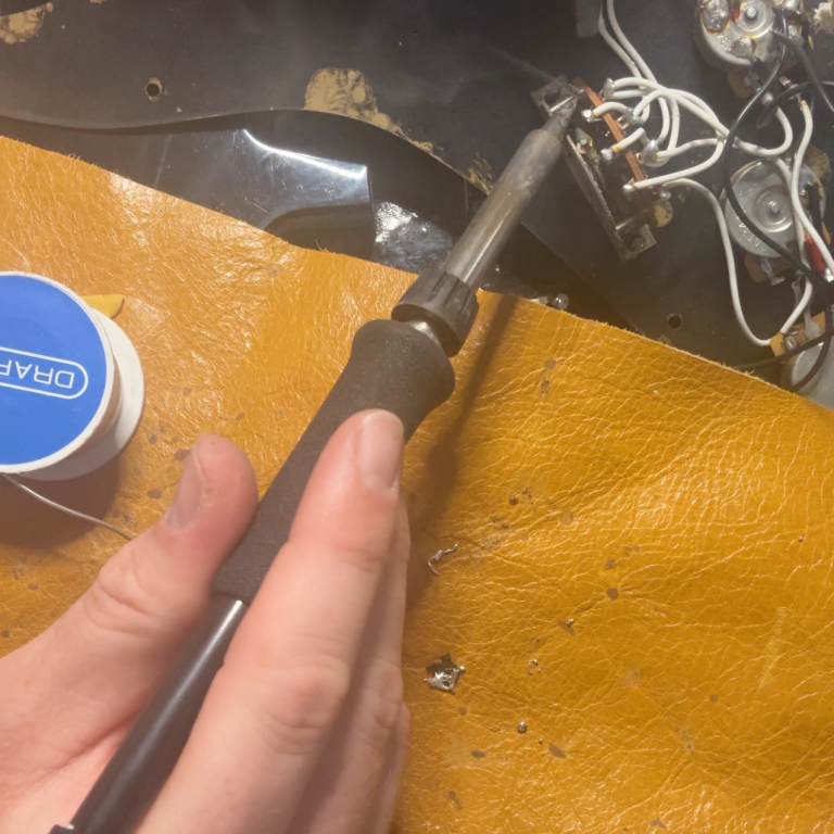 Guitar electronics repair in progress, including pickup wiring and control adjustments
